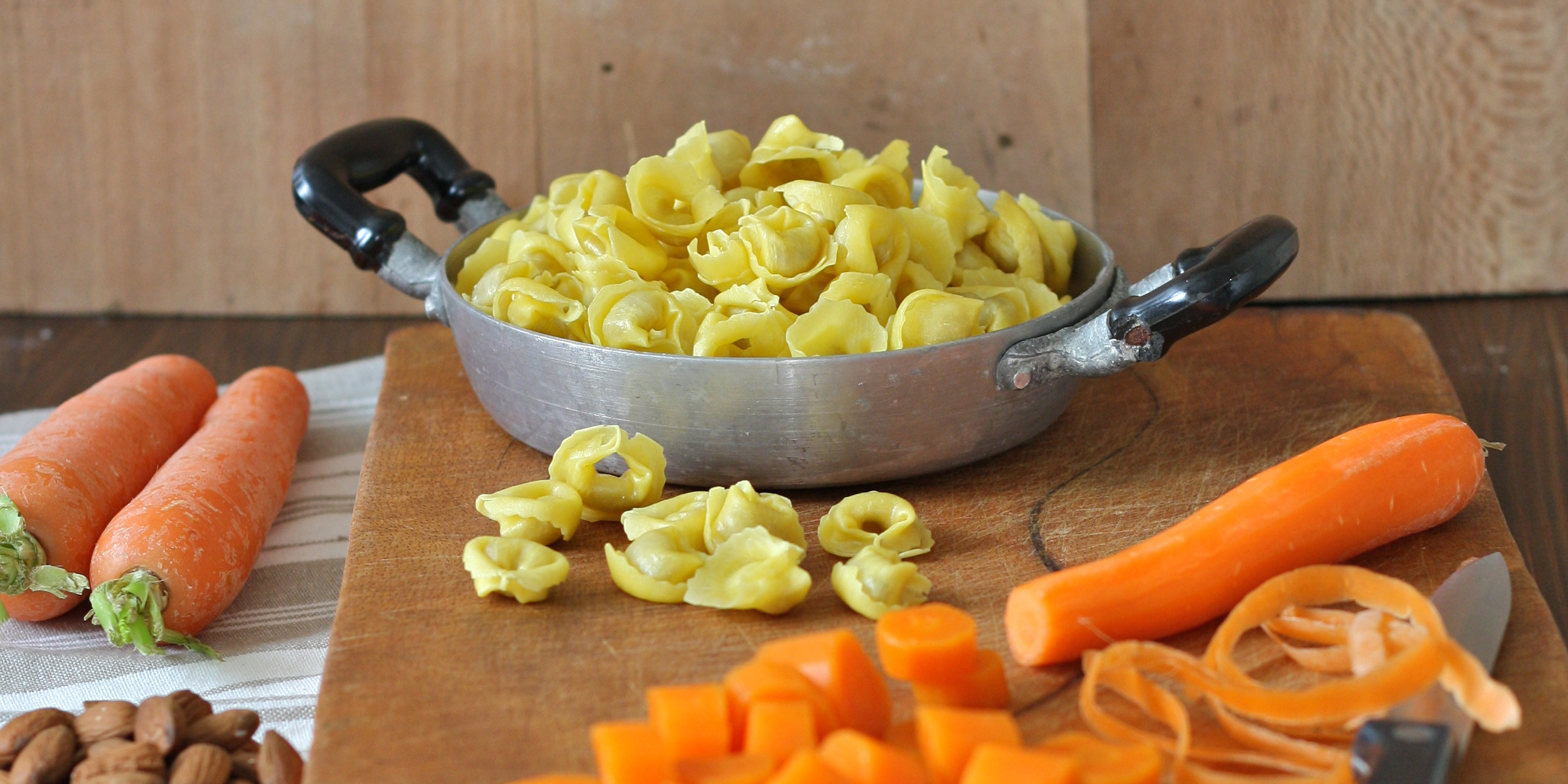 Tortellini with cured ham and velvety carrot, turmeric and almond sauce