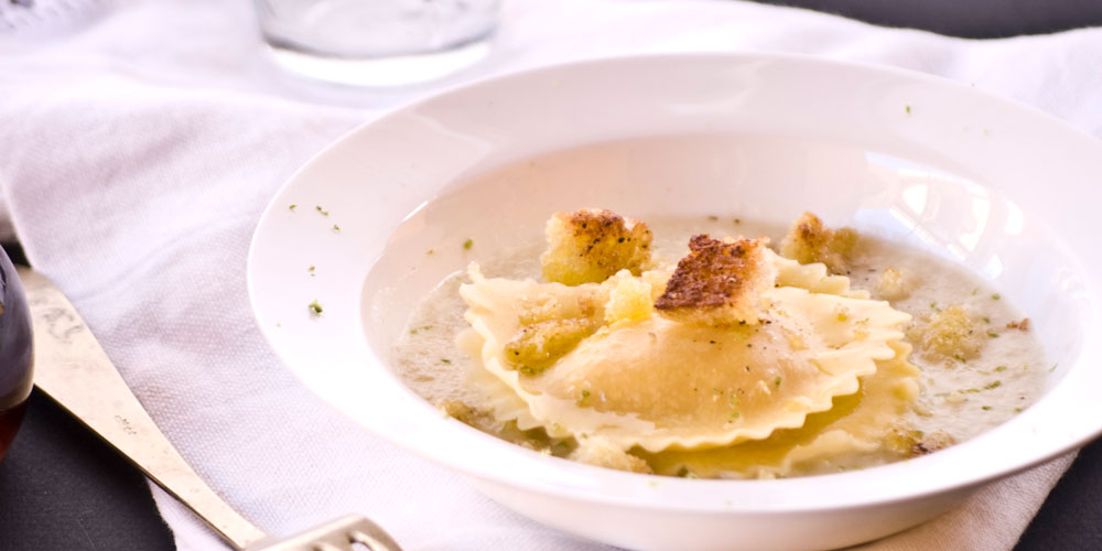 Granpanzerotti gamberi e polpa di granchio con velouté di cipolle al lime e briciole tostate alla colatura di alici