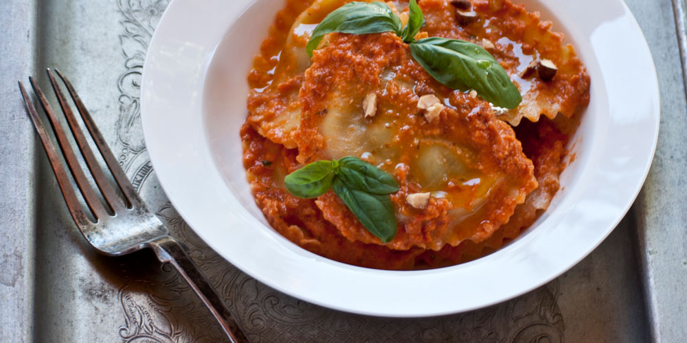 Granpanzerotti ricotta, spinaci e scorza di limone al pesto rosso e mandorle tostate