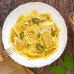 Ravioli Zucca e Pancetta Rosolata con crema allo sciroppo d’acero, nocciole tostate e salvia croccante